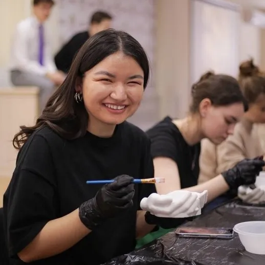 Женщина улыбается во время мастер-класса по рисованию в студии