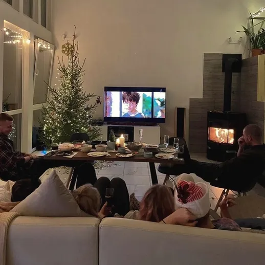 Вечер с друзьями у камина в уютной квартире на фоне рождественской елки