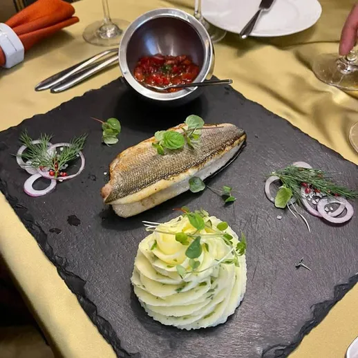 Восхитительное блюдо с рыбой и картофельным пюре в ресторане на ужине