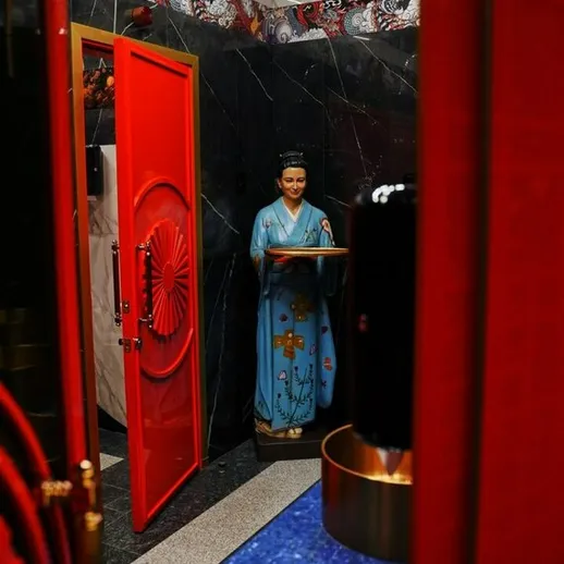 Яркий вход в восточную комнату с фигурой статуи и красной дверью в роскошной атмосфере