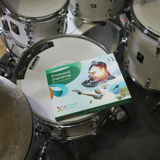 На batterie расположена коробка с материалами для музыкального творчества, стол под инструментом, зал для репетиций