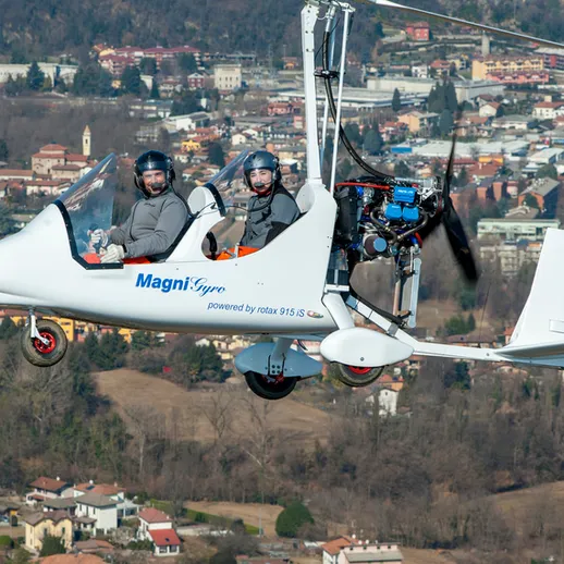 Летающее транспортное средство с двумя пассажирами над городом в ясный день