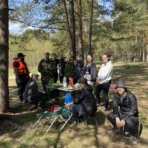 Группа людей на прогулке на природе, готовящих еду и отдыхающих в солнечный день