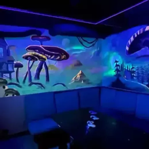 Яркая и необычная стена с мухоморами и пейзажем в комнате с флуоресцентным освещением