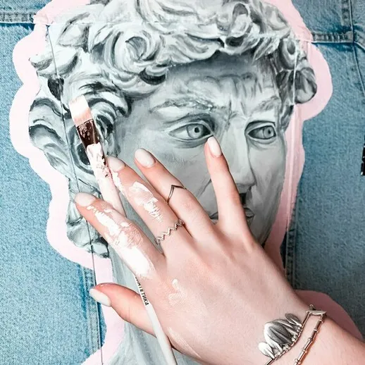 Художник добавляет детали к изображению классической статуи на джинсовой ткани в арт-студии