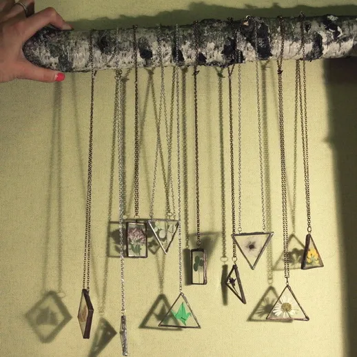 Креативная экспозиция подвесных украшений на деревянной перекладине в уютном интерьере