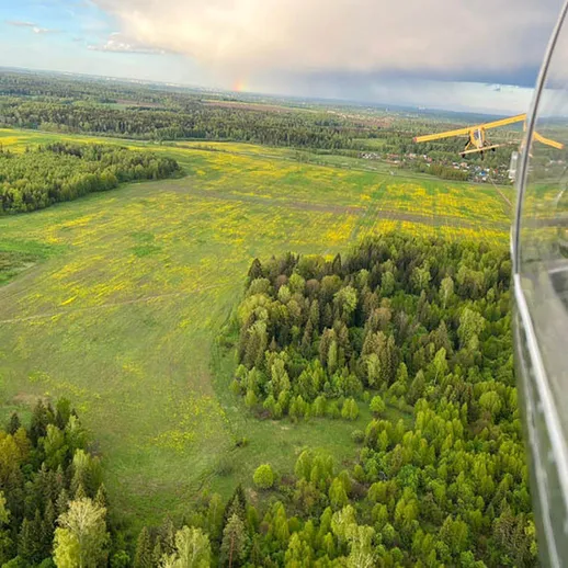 Полет над зелеными полями и лесами во время ясного дня