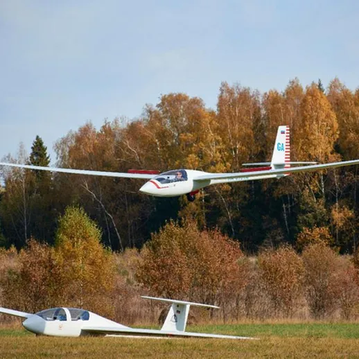 Пара планеров в воздухе над осенним ландшафтом, в ясный день на аэродроме
