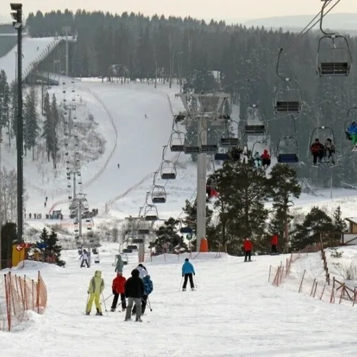 Зимний день на горнолыжном курорте с лыжниками и подъемниками в снежном пейзаже