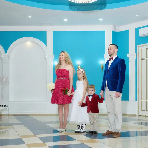 Семья на свадебной фотосессии в красивом зале с голубыми стенами и белыми колоннами