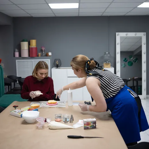 Женщины готовят десерты в уютной кухне на мастер-классе по кулинарии в вечернее время