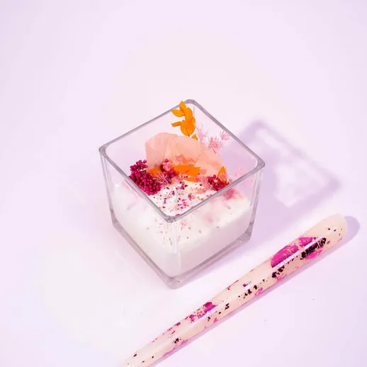 Лепестки цветов и фруктов в десерте с кремом на белом фоне