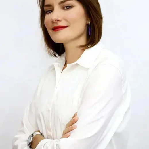 Портрет женщины с короткой стрижкой и яркой помадой на фоне белой стены