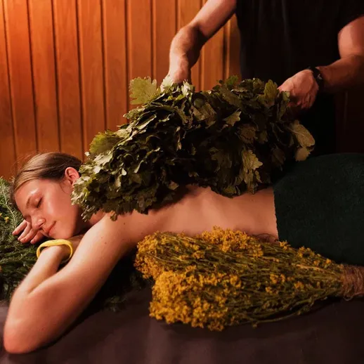 Процедура с использованием трав в спа-салоне с женщиной и мужчиной в помещении