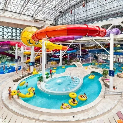 Аквапарк с водными горками и отдыхающими в теплый солнечный день