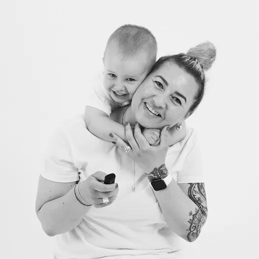 Счастливая мама обнимает сына на нейтральном фоне, выражение радости и любви в моменте, уютное семейное взаимодействие