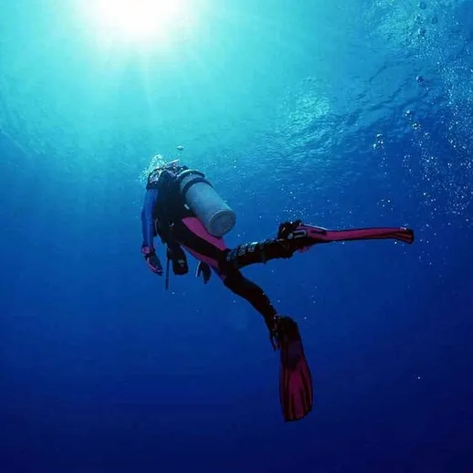 Подводное погружение дайвера в ясные воды океана на глубине в тропическом регионе