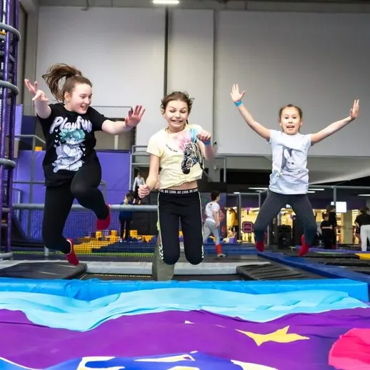 Дети прыгают на батуте в развлекательном центре в зимний период