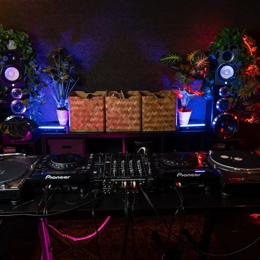 Станция для диджея с оборудованием и растениями в помещении для вечеринки