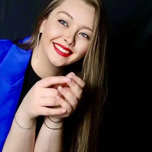 Улыбающаяся девушка с длинными волосами в синем костюме на черном фоне