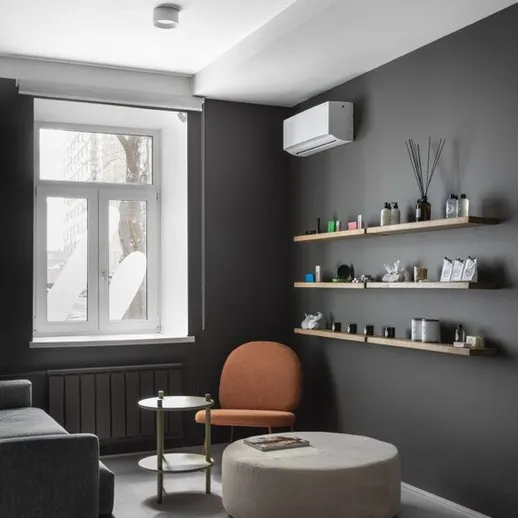 Современный интерьер уютной комнаты с оранжевым креслом и стильными полками в спокойной атмосфере