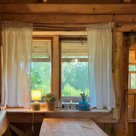 Интерьер деревянного дома с окном и вид на природу в солнечный день