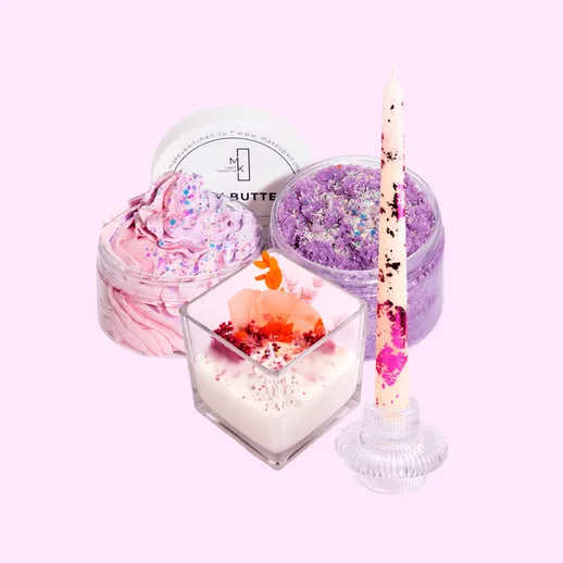 Красивые баночки с ароматными кремами и свеча на розовом фоне для уютного вечера