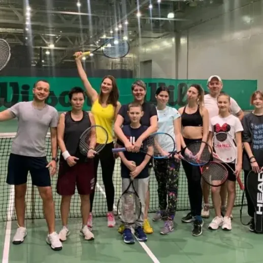 Группа людей на теннисном корте в спортивном центре во время тренировки в преддверии турнира