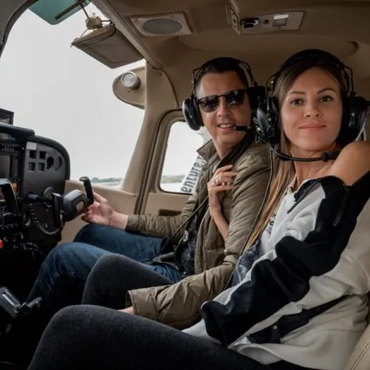 Счастливая пара готовится к полету на небольшом самолете в дождливую погоду