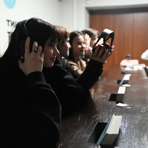 Группа молодых людей в наушниках наслаждается музыкой в музыкальном клубе во время вечеринки