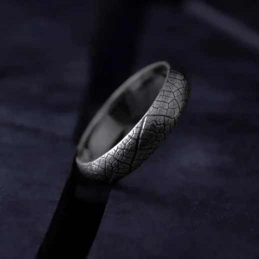 Кольцо с текстурированным дизайном на темном фоне в условиях низкой освещенности