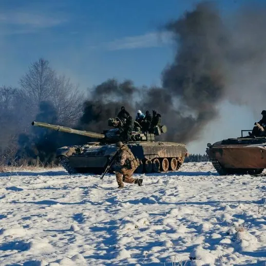 Военные учения с танками и бронетранспортерами зимой на заснеженной местности с дымом