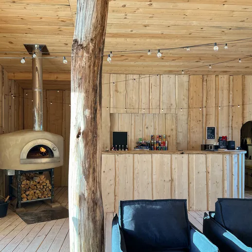 Уютный деревянный интерьер с камином и барной стойкой в загородном доме, идеальном для отдыха