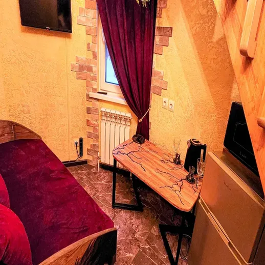 Уютный уголок в загородном доме с диваном и столом, освещенный в мягком свете