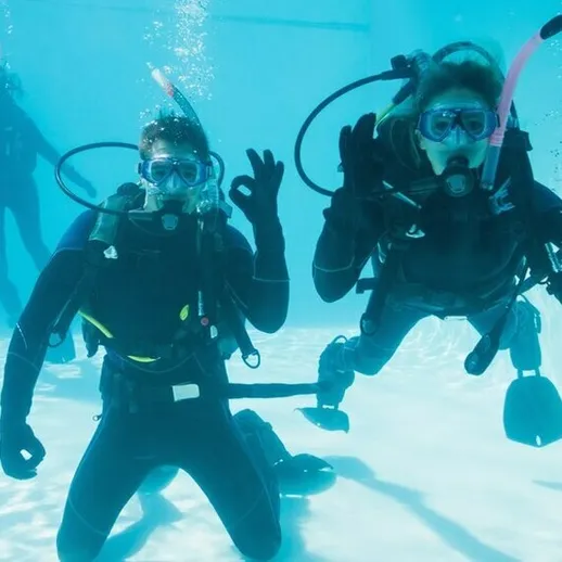 Снорклинг в лагуне на тропическом курорте с тремя дайверами в масках и аквалангах