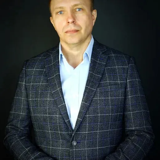 Портрет мужчины в темном костюме на нейтральном фоне в студии