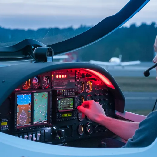 Пилот за управлением самолета на закате, с отображением навигационных данных и приборов на панели