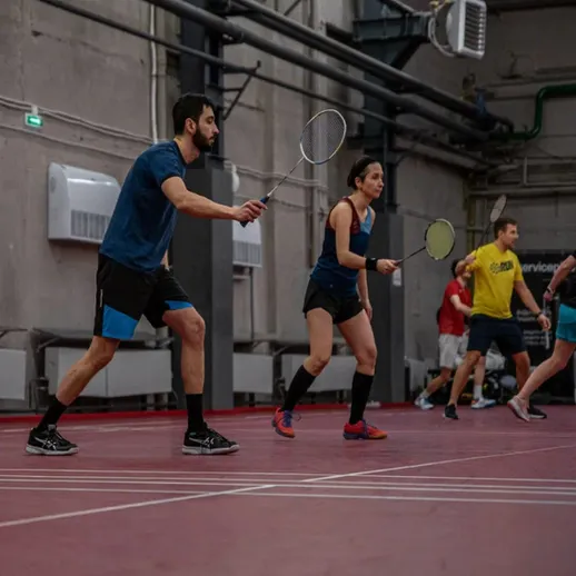 Игроки в бадминтон соревнуются в зале во время вечеринок на активном тренировочном занятии