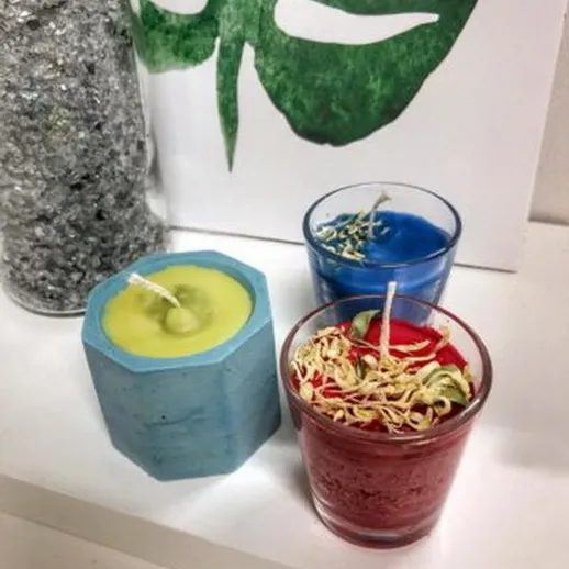 Три ароматические свечи на столе в интерьере с зелеными растениями