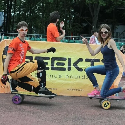 Летнее мероприятие на спортивной площадке с участниками на балансбордах и зрителями