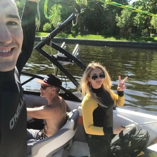 Летний день на воде: молодые люди наслаждаются вейкбордингом на реке с ярким солнцем