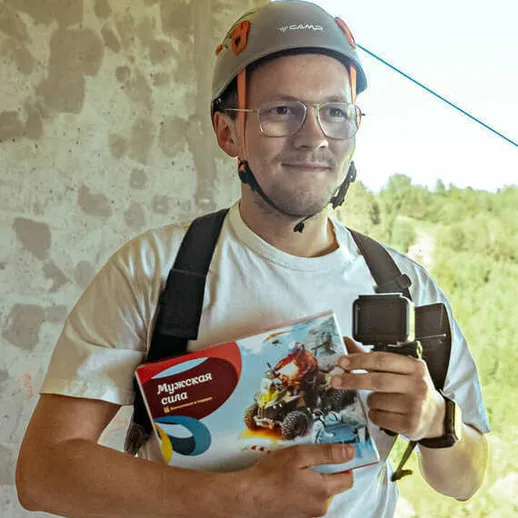 Молодой человек с книгой на фоне природы, готовящийся к активному отдыху на скалах
