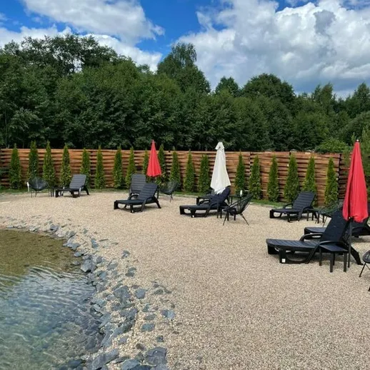 Уединённый пляжный уголок с шезлонгами и зонтиками у воды в солнечный день