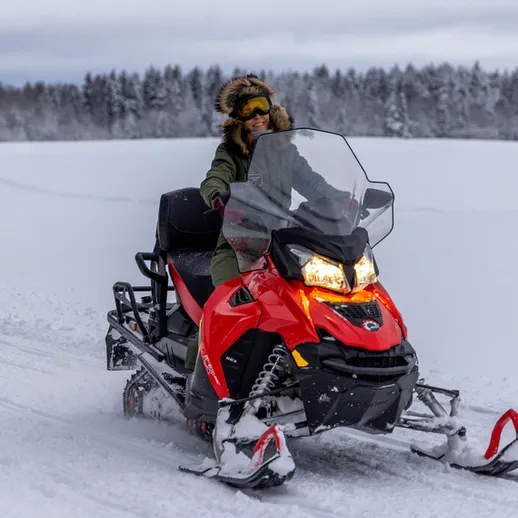 Снегокат и зимний пейзаж в лесу, поездка по зимнему ландшафту