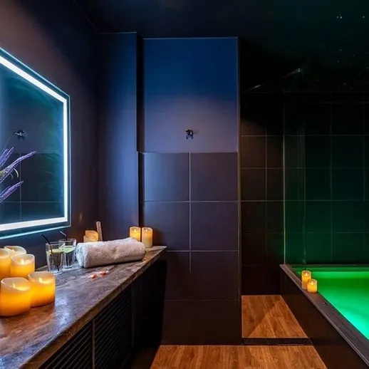 Внутренний спа-центр с бассейном и свечами для расслабления в темном помещении