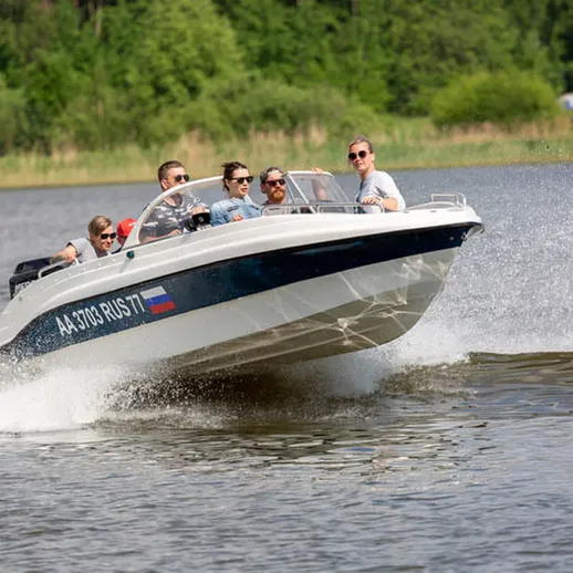 Летний отдых на моторной лодке с друзьями на реке в красивом природном окружении