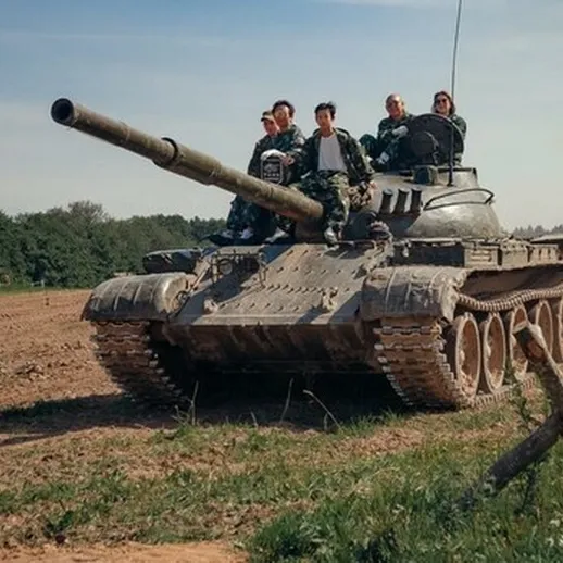 Танковая тренировка на открытом поле с участниками и техникой на фоне летнего пейзажа