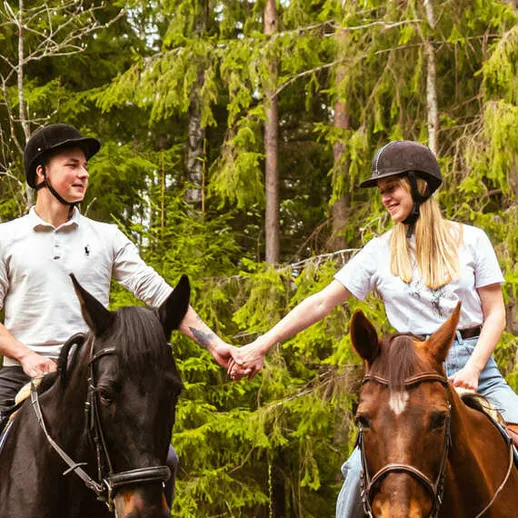Прогулка на лошадях в лесу: молодая пара наслаждается моментом на свежем воздухе в красивой природной обстановке Прогулка на лошадях в лесу: молодая пара наслаждается моментом на свежем воздухе в красивой природной обстановке