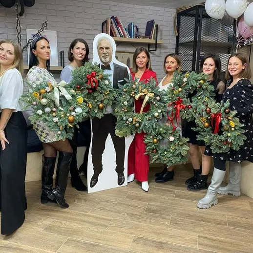 Женщины с рождественскими венками на праздничной встрече в уютном помещении