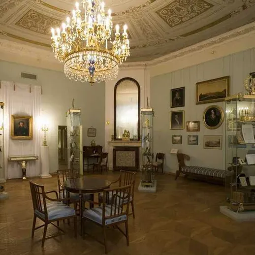 Уютная библиотека с хрустальной люстрой, коллекцией книг и произведений искусства в историческом особняке